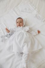 Дитяча хрестильна сукня з аксесуарами на світлому тлі